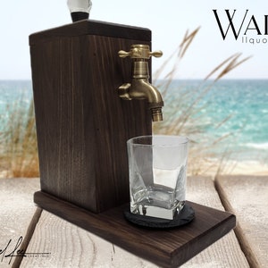 May include: A dark walnut liquor dispenser with a brass spigot and a clear glass. The dispenser is on a wooden base with a coaster and a glass. The text "WALNUT liquor dispenser" is visible.