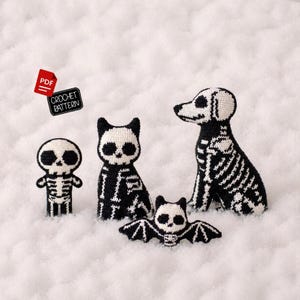 Könnte beinhalten: Vier schwarz-weiße Häkelfiguren, bestehend aus einem kleinen menschlichen Skelett, einem Katzenskelett, einem Hundeskelett und einem Fledermausskelett. Ein kleines rotes Symbol mit dem Text PDF und ein schwarzes Etikett mit dem Text CROCHET PATTERN.