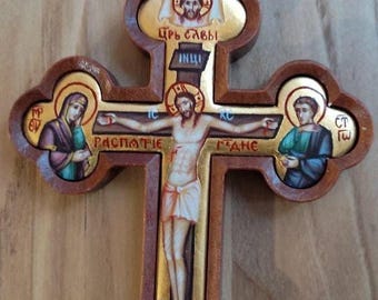 May include: A wooden cross with a gold background and painted images of Jesus Christ, Mary, and John the Baptist. The cross is decorated with gold accents and the text "ЦРЬ СЛАВЫ" (King of Glory) and "РАСПЯТИЕ" (Crucifixion).