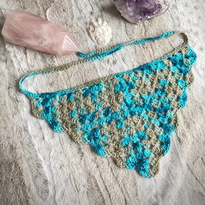 Detailed view of the handmade crochet work on the Aphrodite Shell Hair Bandana, highlighting the fine craftsmanship and unique shell edge. The color option is Coastal, a blue and tan multicolored triangle with matching edges and ties.