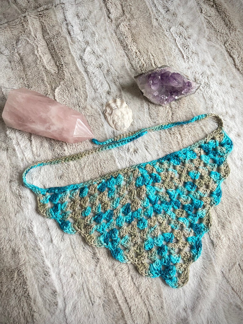 Detailed view of the handmade crochet work on the Aphrodite Shell Hair Bandana, highlighting the fine craftsmanship and unique shell edge. The color option is Coastal, a blue and tan multicolored triangle with matching edges and ties.