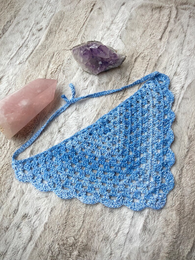Detailed view of the handmade crochet work on the Aphrodite Shell Hair Bandana, highlighting the fine craftsmanship and unique shell edge. The color option is Bluebell, a multi-shade blue triangle with matching edging and ties.