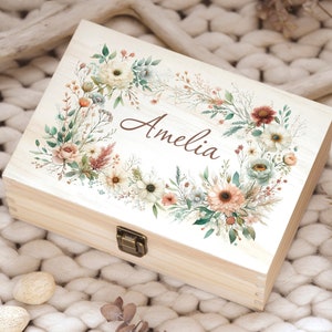 May include: A wooden box with a hinged lid, decorated with a watercolor floral wreath and the name "Amelia".
