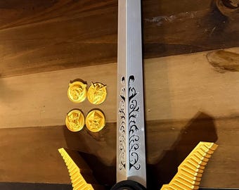 May include: A silver and gold toy sword featuring a pointed tip, a central blade with black decorative engravings, and a hilt with gold wing-like guards, red accents, and a black circular center. Four small gold circular medallions are included.