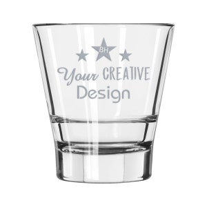 May include: A clear, tapered shot glass with the text "Your CREATIVE Design" in a light gray script. Above the text are three gray stars, with a star-shaped logo in the center. The glass has a thick base and is suitable for various beverages.