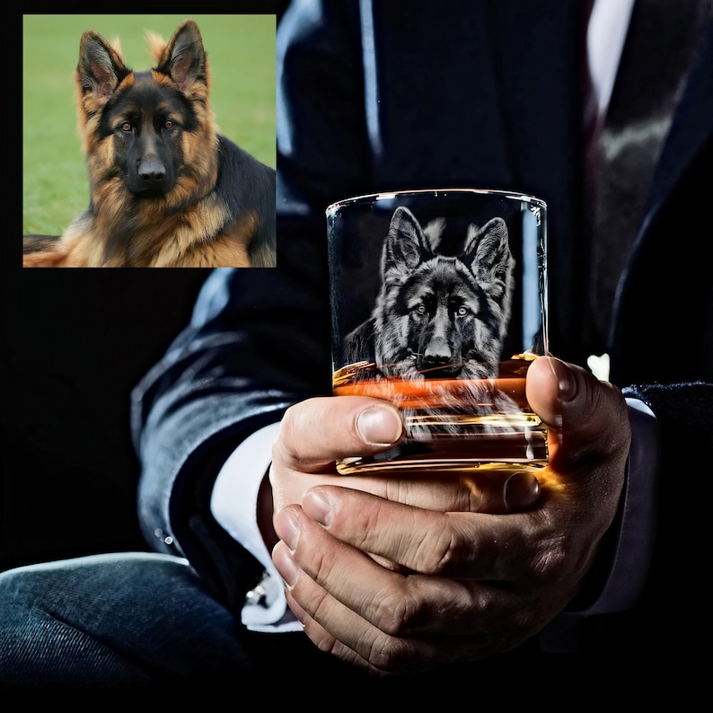 Puede incluir: Un vaso de cristal transparente con un perro pastor alem&aacute;n grabado en el lateral. El vaso est&aacute; lleno de l&iacute;quido &aacute;mbar y est&aacute; siendo sostenido por las manos de una persona.