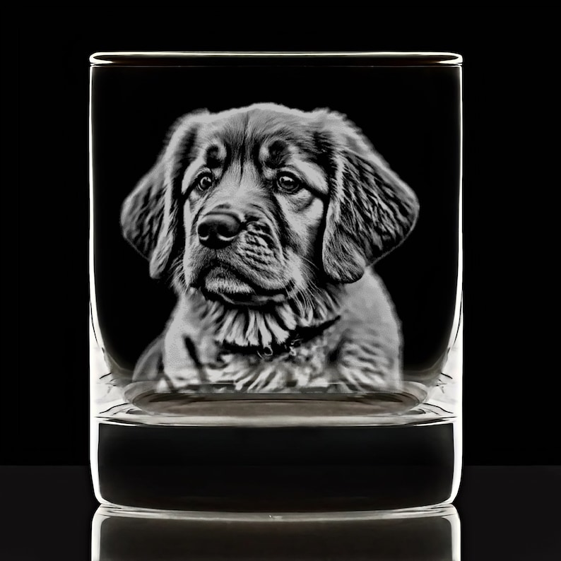 Puede incluir: Una imagen grabada en blanco y negro de la cabeza de un perro en un vaso de vidrio transparente.