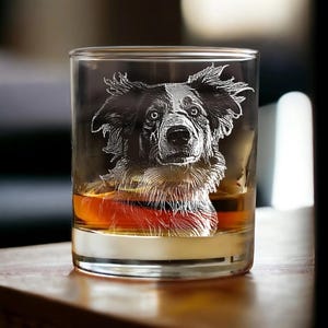 Puede incluir: Un vaso de vidrio transparente con un perro blanco y negro grabado en el lateral. El vaso est&aacute; lleno de l&iacute;quido &aacute;mbar.