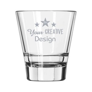 May include: A clear, tapered glass with a thick base. The glass features the text "Your CREATIVE Design" in a light gray font, along with three stars and the initials "BH". The glass is designed for beverages.