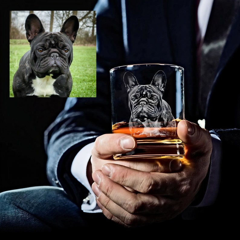 Puede incluir: Un vaso de cristal transparente con un Bulldog Franc&eacute;s grabado en el lateral. El vaso est&aacute; lleno de un l&iacute;quido dorado y est&aacute; siendo sostenido por la mano de una persona.