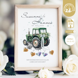 May include: A framed print featuring a green tractor decorated with flowers and ribbons, with the names "Susanne & Hannes" and the date "07. JULI 2025" above it. The print includes the text "WIR WÜNSCHEN EUCH ALLES LIEBE ZUR HOCHZEIT".