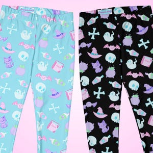 May include: Two pairs of leggings with a repeating pattern of Halloween-themed graphics. One pair is light blue, the other black. The graphics include skulls, witch hats, potion bottles, cats, ghosts, bats, and crossbones. The leggings are from the "Narkyuko Club".