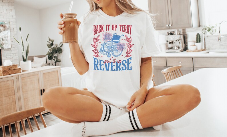 May include: White t-shirt with a red and blue graphic of a wheelchair with the text "Back it up Terry put it in reverse".