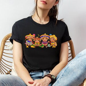 May include: Black t-shirt with a graphic of four brown cows wearing colorful sombreros and holding maracas. The cows are wearing traditional Mexican clothing.