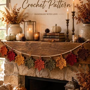 May include: A crochet pattern for a maple leaf garland featuring the text MAPLE LEAF GARLAND Crochet Pattern HANDMADE WITH LOVE. The image displays a garland of crocheted maple leaves in shades of red, orange, yellow, and green on a rope.