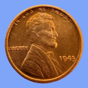 May include: A close-up of a copper-colored 1943 Lincoln penny. The obverse side features a profile of Abraham Lincoln, the word "LIBERTY", and the year "1943". The coin also has the inscription "IN GOD WE TRUST".