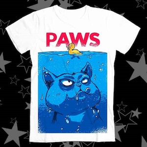 May include: White t-shirt with a blue and white illustration of a cat underwater with a yellow rubber ducky floating above. The text "PAWS" is printed in red letters above the cat.
