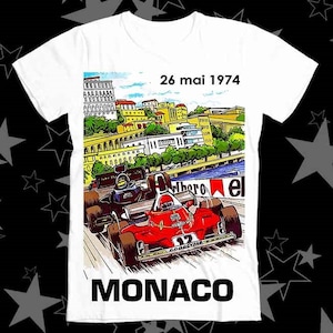 May include: White t-shirt with a graphic of a red and white race car on a track in Monaco. The text "26 mai 1974" and "MONACO" are printed on the shirt.