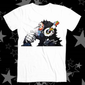 May include: White t-shirt featuring a colourful graphic of a monkey wearing headphones. The monkey is looking to the side and has a thoughtful expression.