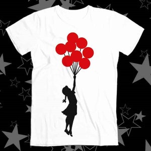 Puede incluir: Una camiseta blanca con una silueta negra de una persona sosteniendo globos rojos.