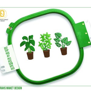 May include: Three embroidered designs of potted plants in a green embroidery hoop. The plants are a leafy green plant, a plant with small green leaves, and a plant with large green leaves. The hoop is on a white background.