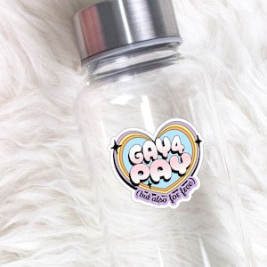 May include: Clear glass water bottle with a sticker that says "Gay 4 Pay (but also for free)" in a rainbow heart shape.
