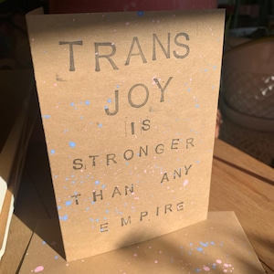 Trans Joy jest silniejsza niż każde imperium, ręcznie robiona kartka ze znaczkiem, apokaliptyczny humor dla kochanków