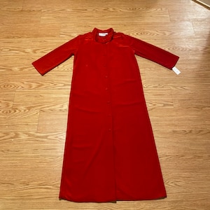 May include: A long, red, button-down dress with a collar and three-quarter sleeves.