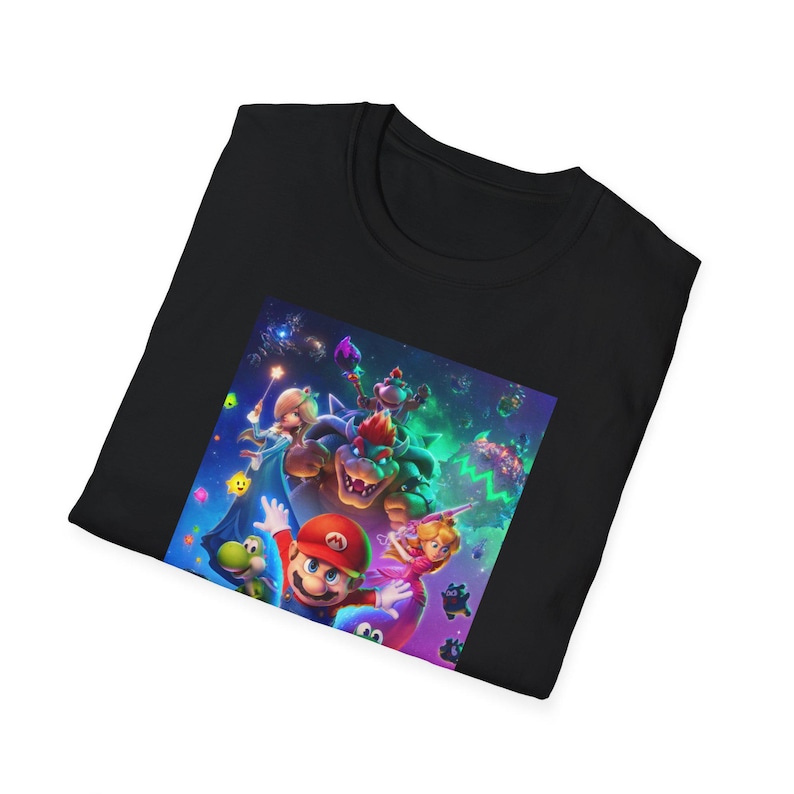 Folded black gamer t shirt showing part of the Super Mario Galaxy inspired design. The folded presentation highlights the upper section of the colorful cosmic artwork including stars galaxy elements and playful platform game character details. The image emphasizes the soft cotton texture of the Gildan 64000 shirt and the vibrant high quality print used for the retro gaming design.
