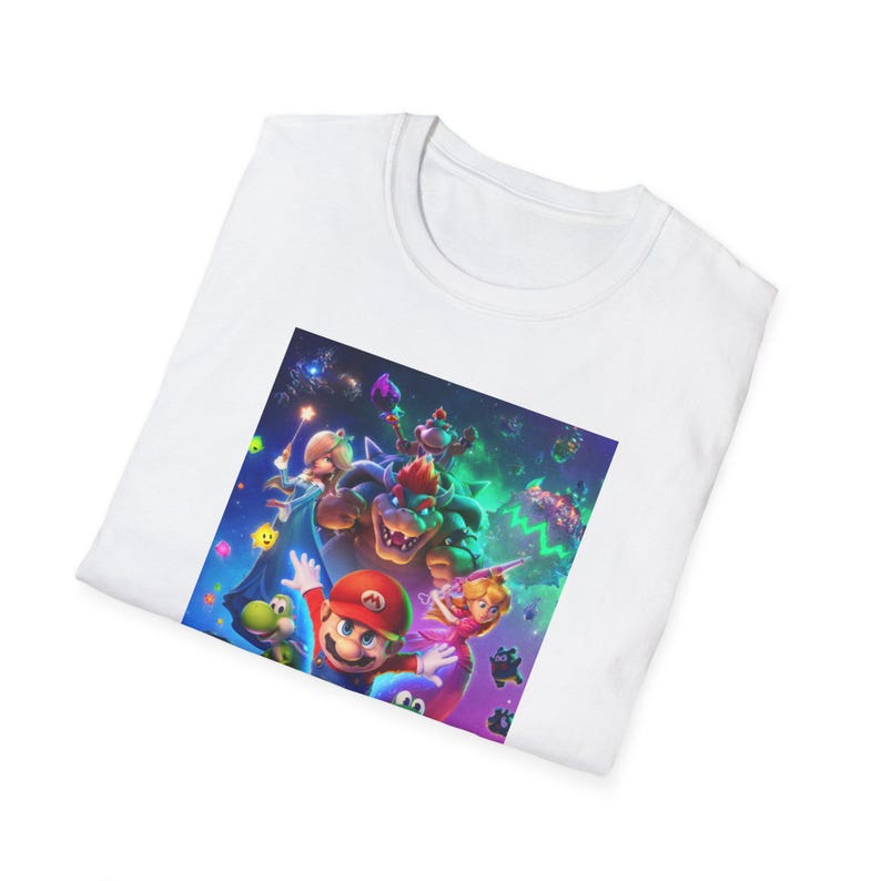 Folded white gamer t shirt showing part of the Super Mario Galaxy inspired design. The folded presentation highlights the upper section of the colorful cosmic artwork including stars galaxy elements and playful platform game character details. The image emphasizes the soft cotton texture of the Gildan 64000 shirt and the vibrant high quality print used for the retro gaming design.