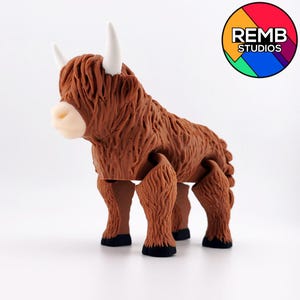 May include: A brown, furry, articulated toy Highland cow with white horns. The toy is standing on a white surface.