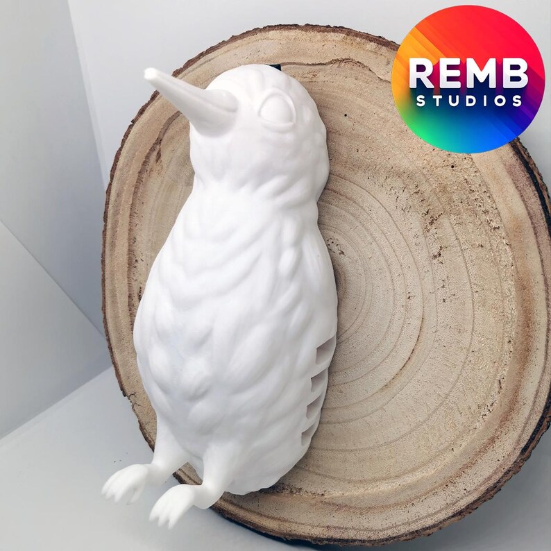 K&ouml;nnte beinhalten: Wei&szlig;e Keramik-Vogelskulptur mit langem Schnabel, auf einer Holzscheibe platziert. Der Vogel hat eine strukturierte Oberfl&auml;che und scheint eine stilisierte Darstellung eines echten Vogels zu sein.