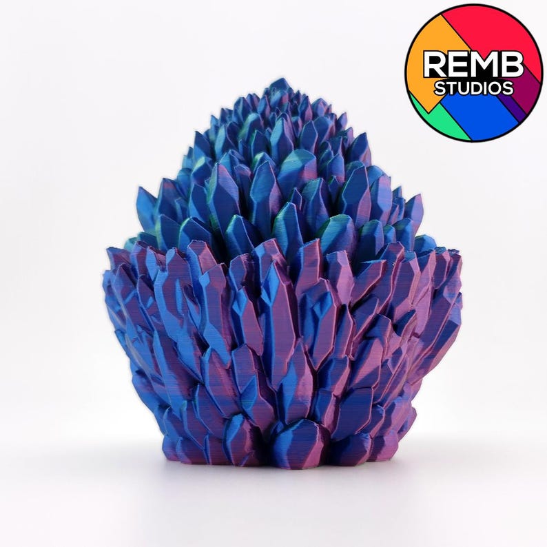 May include: A 3D-printed sculpture of a cluster of crystalline structures. The sculpture features a gradient of colors, transitioning from deep purple at the base to vibrant blue at the tips. The overall shape is roughly conical, with sharp, angular facets.