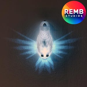 K&ouml;nnte beinhalten: Ein wei&szlig;es, keramikartiges Nachtlicht in Vogelform mit einem blauen Schein, der von ihm ausgeht. Das Licht wirft einen Schatten der Fl&uuml;gel des Vogels auf die Wand hinter ihm.