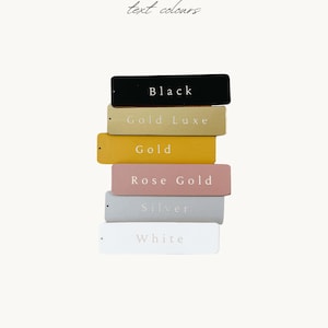 A stack of six rectangular tags, each with a different color, representing the text colors: Black, Gold Luxe, Gold, Rose Gold, Silver, and White.