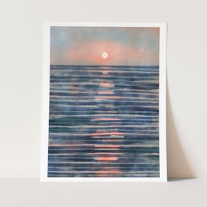 May include: A watercolor print of a sunset over the ocean. The sun is a soft orange circle, reflecting a warm glow on the water. The ocean is depicted with horizontal blue and teal brushstrokes.