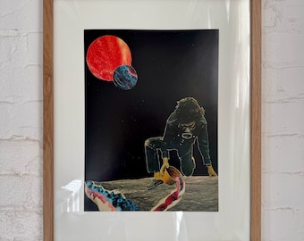 Peut inclure: Une œuvre d'art en collage encadrée représentant une personne agenouillée sur une surface blanche, versant un liquide d'un récipient. L'arrière-plan est bleu foncé avec une planète rouge et bleue.