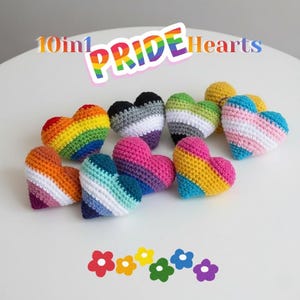 May include: A collection of ten small, crocheted heart-shaped items featuring various pride flag color patterns. The text 10in1 PRIDE Hearts is displayed at the top, and five colorful flower icons are arranged at the bottom of the image.