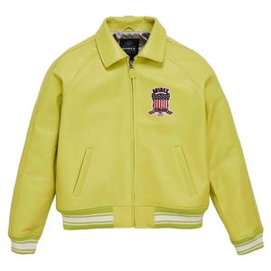 May include: A chartreuse leather jacket with a collared neckline and a zip closure. The jacket features a patch on the chest with the text "AVIREX" and an American flag design. The cuffs and hem have white and green striped detailing.