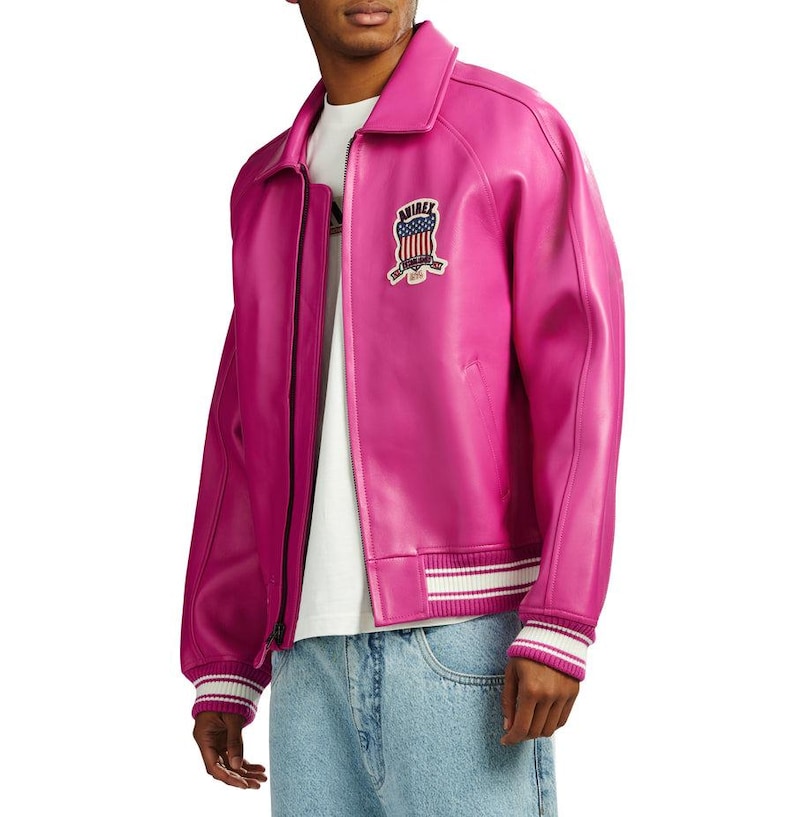 K&ouml;nnte beinhalten: Leuchtend fuchsiafarbene Lederjacke im Bomber-Stil. Mit Kragen, Rei&szlig;verschluss und gerippten B&uuml;ndchen und Saum mit wei&szlig;en Streifen. Auf der Brust befindet sich ein gestickter Aufn&auml;her mit amerikanischer Flagge.