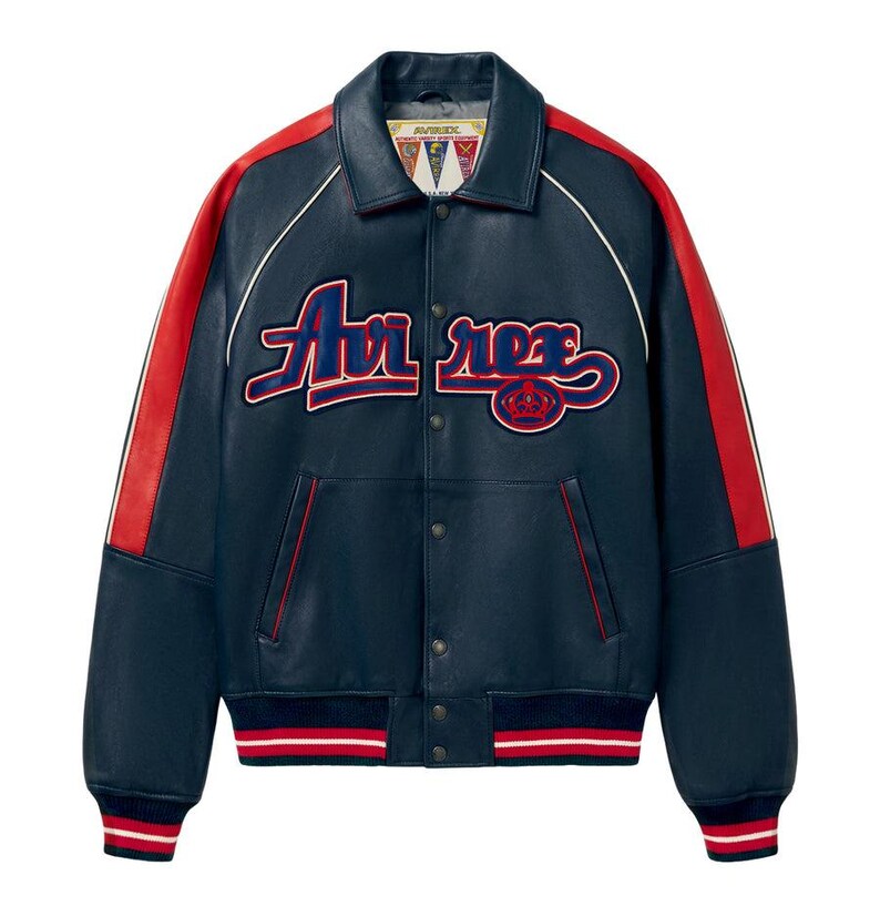 Puede incluir: Chaqueta de cuero azul marino con detalles rojos en las mangas y el cuello. La chaqueta presenta el texto "Avi rex" en una fuente cursiva en el pecho, con un dobladillo y pu&ntilde;os a rayas rojas y blancas. Estilo universitario cl&aacute;sico.