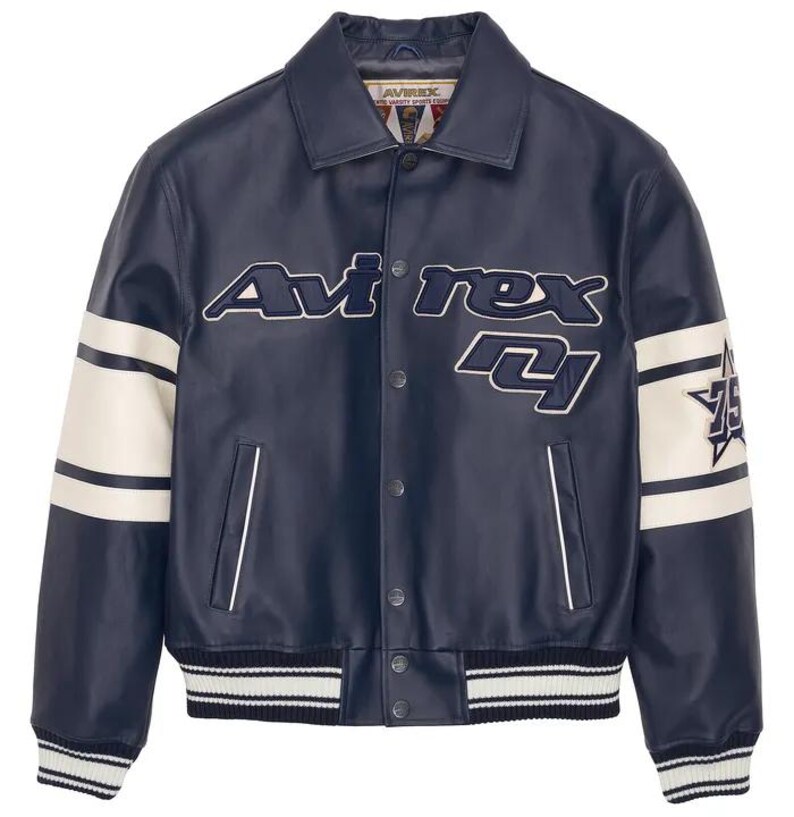 May include: Navy blue leather jacket with white detailing. The jacket features the text "Avirex" in white and blue, and the number "75" on the sleeve. It has a button-up front and a ribbed hem and cuffs.