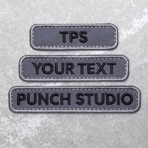 May include: Three grey embroidered patches with white stitching. The top patch says "TPS". The middle patch says "YOUR TEXT". The bottom patch says "PUNCH STUDIO".