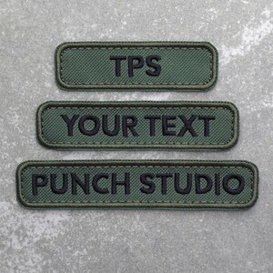 May include: Three green fabric patches with black embroidered text. The top patch reads "TPS", the middle patch reads "YOUR TEXT", and the bottom patch reads "PUNCH STUDIO".