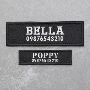 May include: Two black embroidered patches. The larger patch reads "BELLA" above a phone number in white thread. The smaller patch reads "POPPY" above a phone number in white thread.