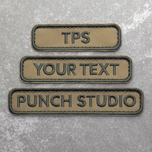 May include: Three tan and green embroidered patches. The top patch says "TPS". The middle patch says "YOUR TEXT". The bottom patch says "PUNCH STUDIO".