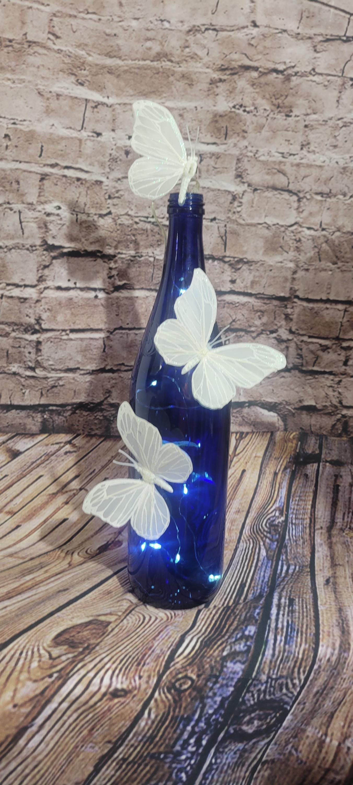 Cobalt blue wine bottle electric LED lights with white butterflies table decor centerpiece - Thumbnail 4