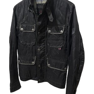 Peut inclure: Veste noire avec plusieurs poches avant, un col montant et une fermeture boutonnée. La veste a un éclat subtil et un design classique, adapté à diverses occasions.