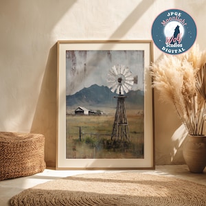 May include: Framed artwork featuring a rustic windmill in a rural landscape. The painting depicts a weathered windmill with a white fan against a backdrop of mountains and a cloudy sky. The artwork is in a wooden frame.
