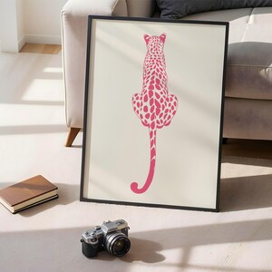 Trendy Pink Leopard Wall Art Print featuring a bold pink leopard on soft tones, perfect for girls rooms, preppy dorm decor, dopamine interiors, or jungle-inspired bedrooms. This funky animal print adds a stylish and vibrant touch to your apartment or teen room decor. Ideal for fans of maximalist wall art, aesthetic animal posters, or unique pink bedroom art. A standout piece that blends fashion vibes with wild, bold energy.